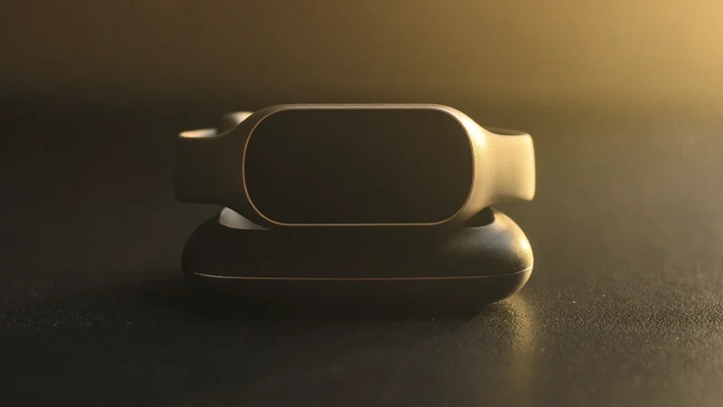 Bracelet connecté à écran sombre installé sur son petit socle de recharge